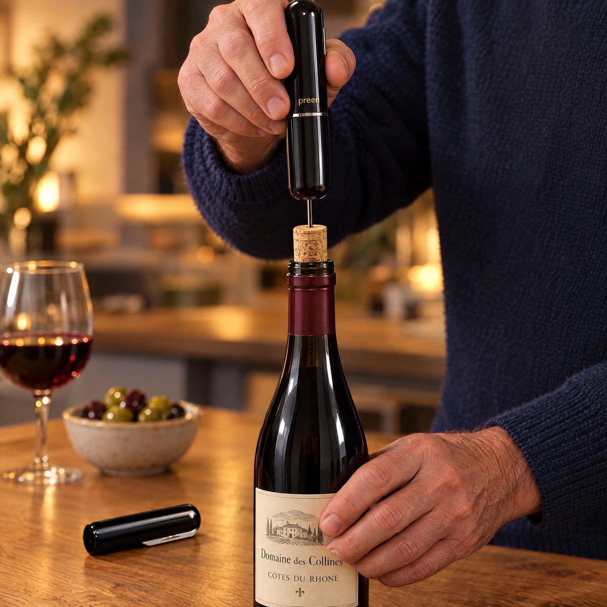 The Preen Opener lifting a cork out of a bottle of red